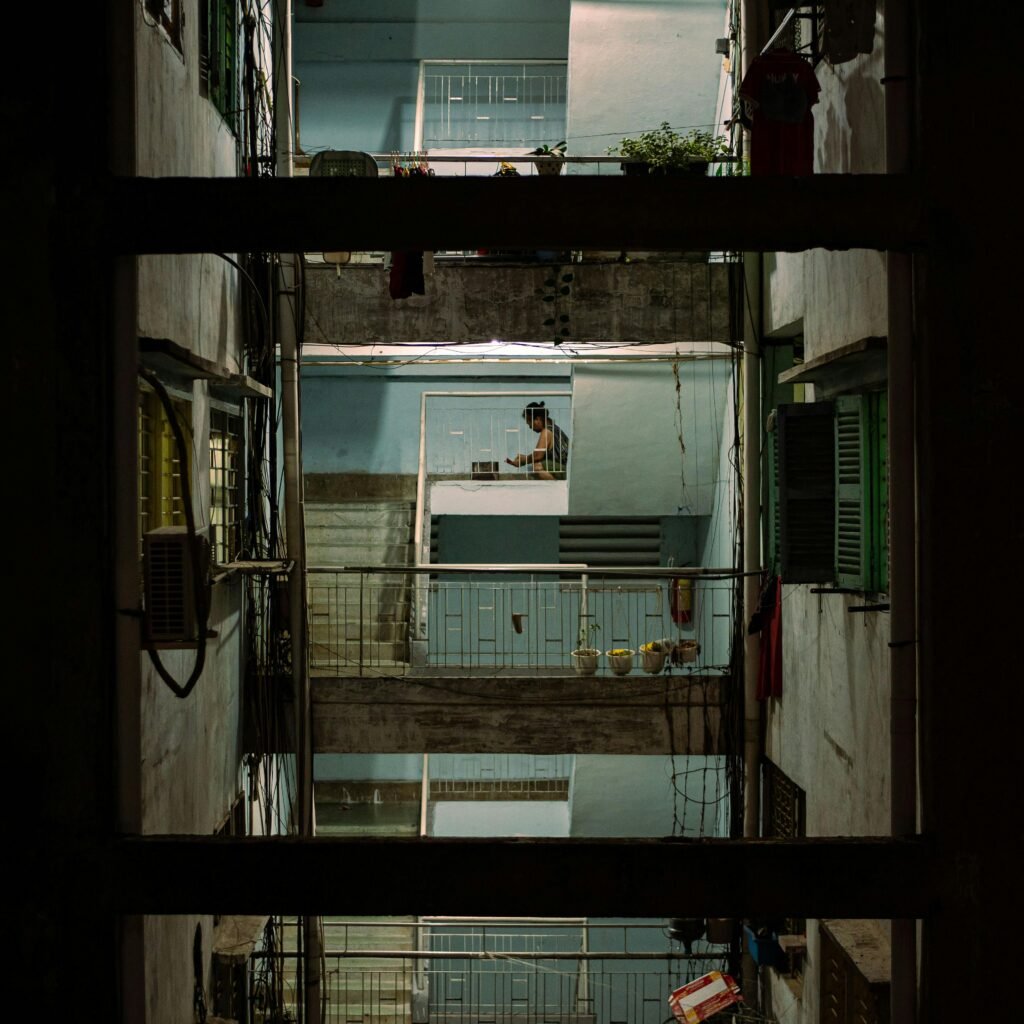 pexels-photo-20324813-20324813 View of a multi-story urban building interior, showcasing railings and balconies at night.