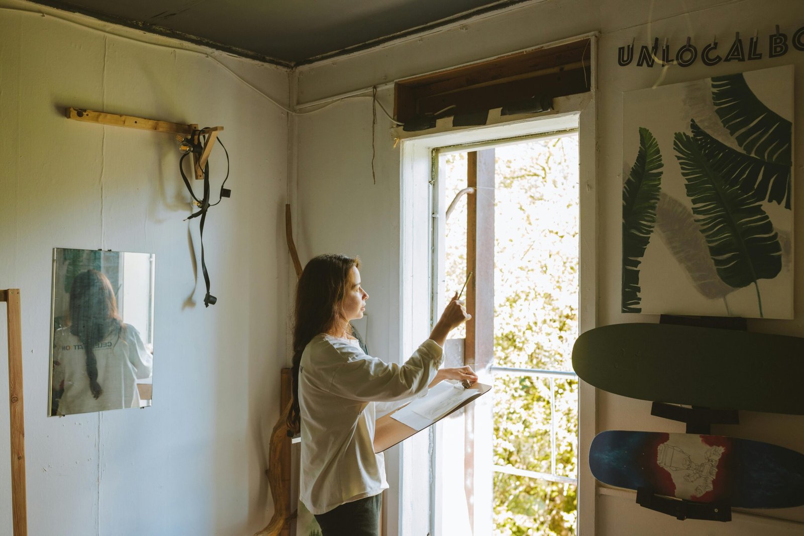 A woman stands near a doorway holding a clipboard in a creatively decorated room.